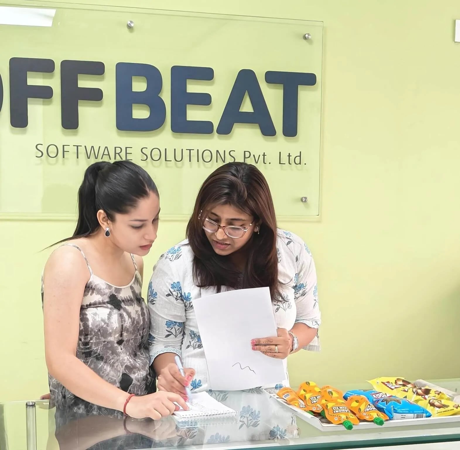 Two Offbeat team members reviewing project notes at the Mohali office